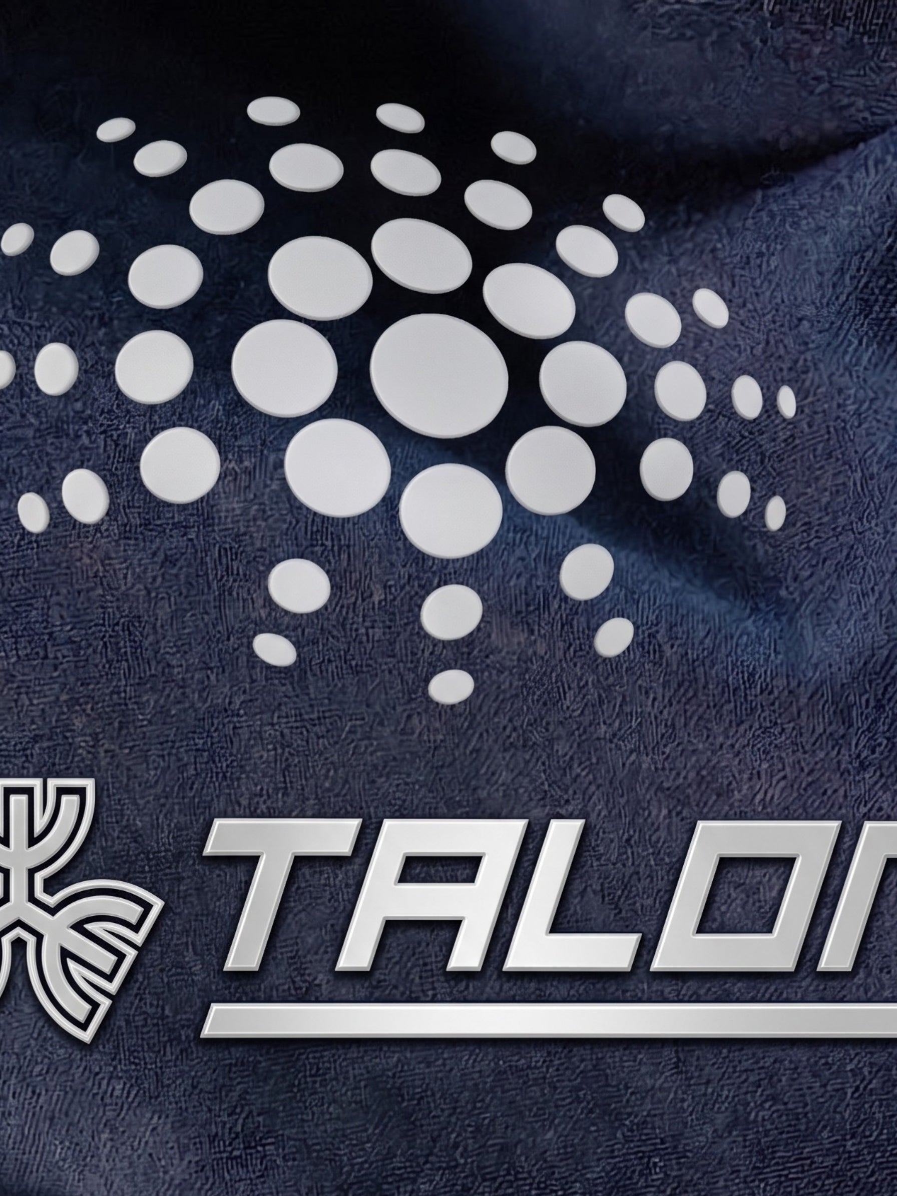 Raised silicone stamping on navy sportswear showing TALON logo and dot pattern detail.