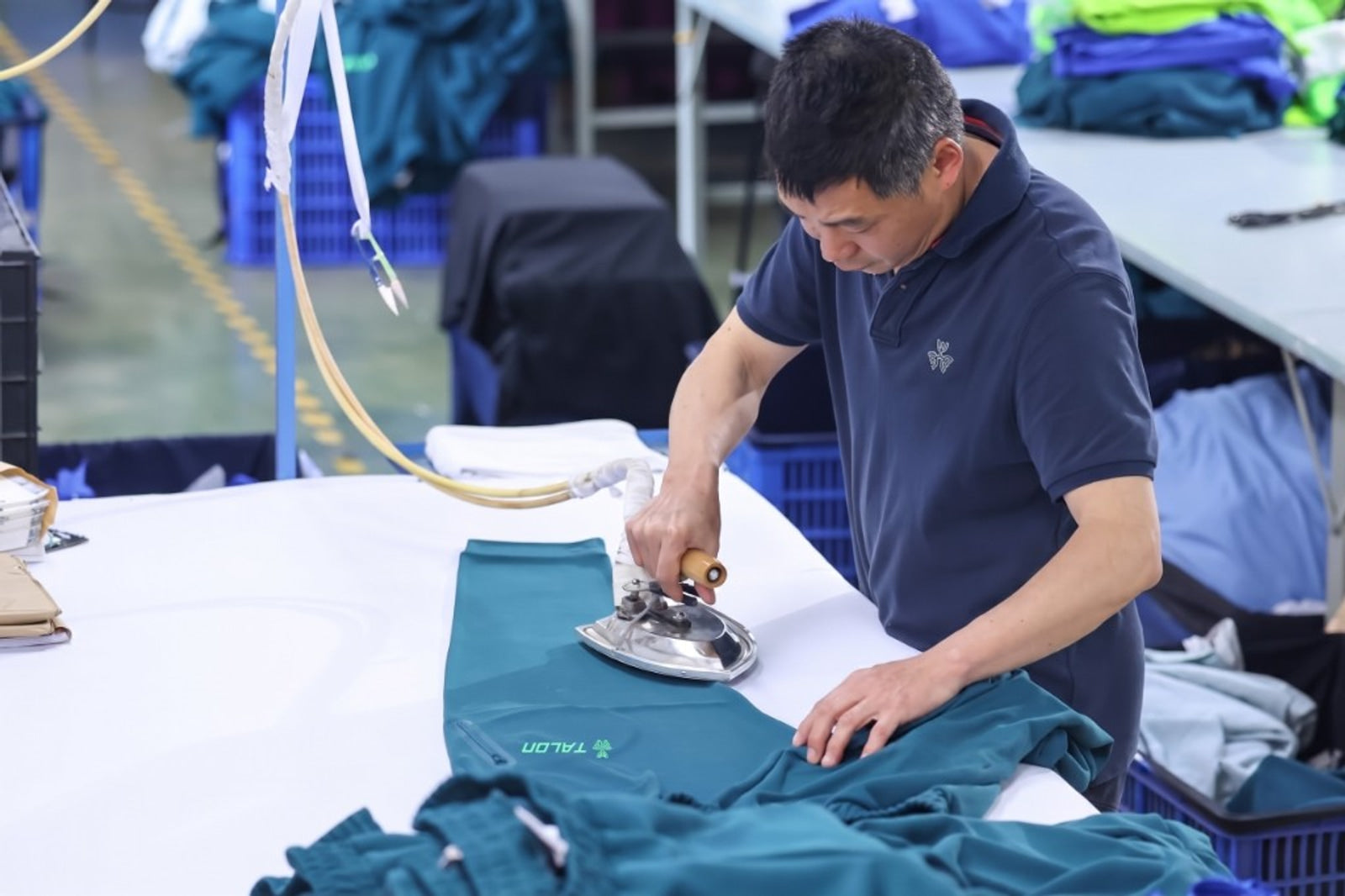 Industrial garment ironing and steam pressing at TALON factory — TALON OEM manufacturing