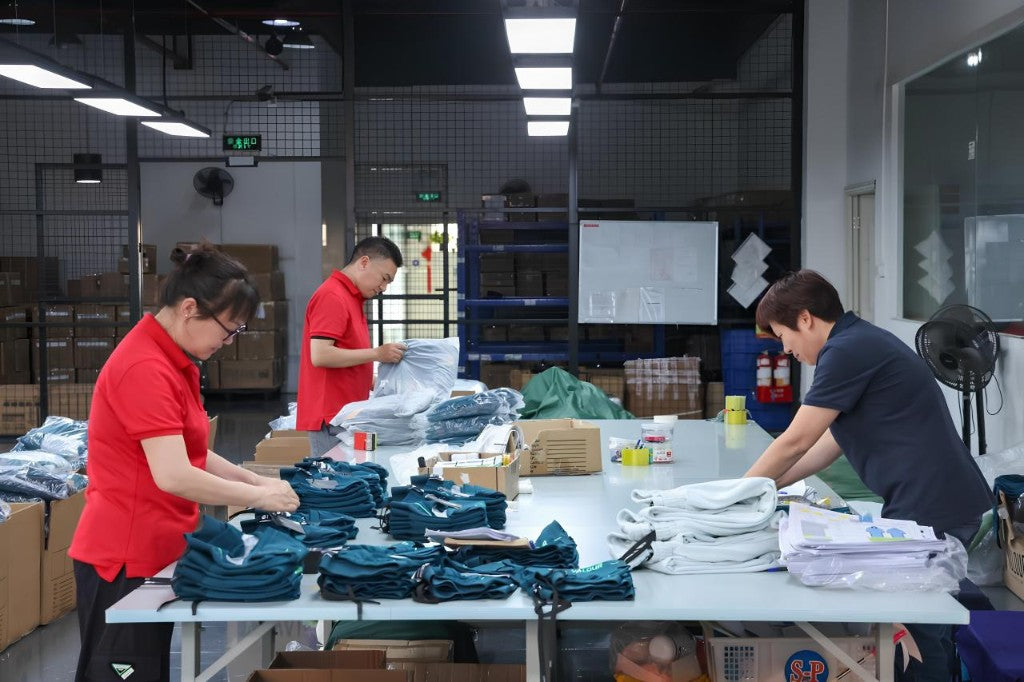 QC inspection and garment folding at TALON factory packing table — TALON OEM manufacturing
