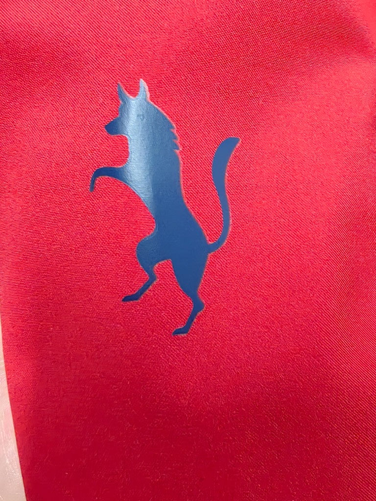 Durable heat-seal silicone transfer logo applied to red fabric.