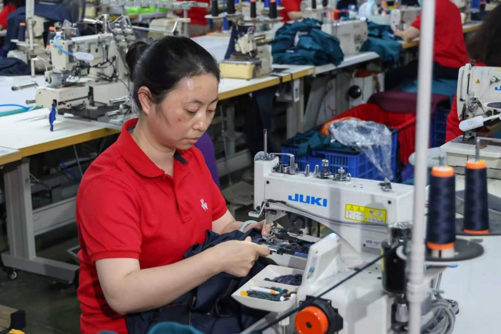 Hand stitching and sewing operator at TALON garment assembly line — TALON OEM manufacturing