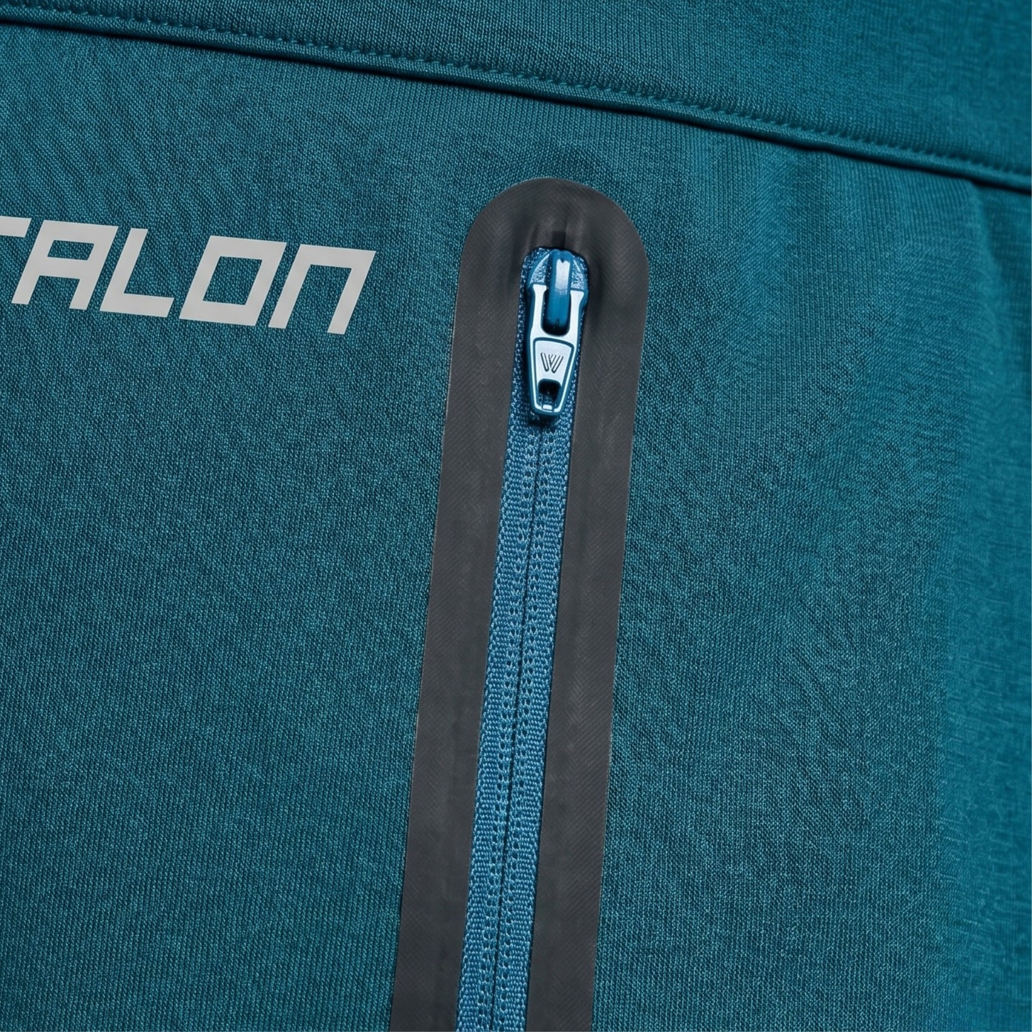 TALON polyurethane-coated waterproof zipper on teal technical sportswear with bonded seam.