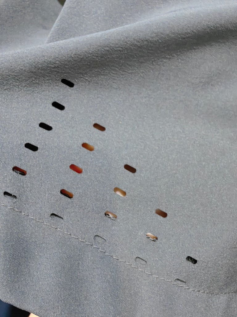 Precision laser cut ventilation holes on breathable athletic fabric.